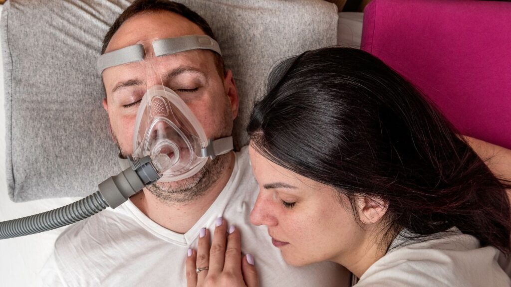 man sleeping with CPAP mask because of obstructive sleep apnea
