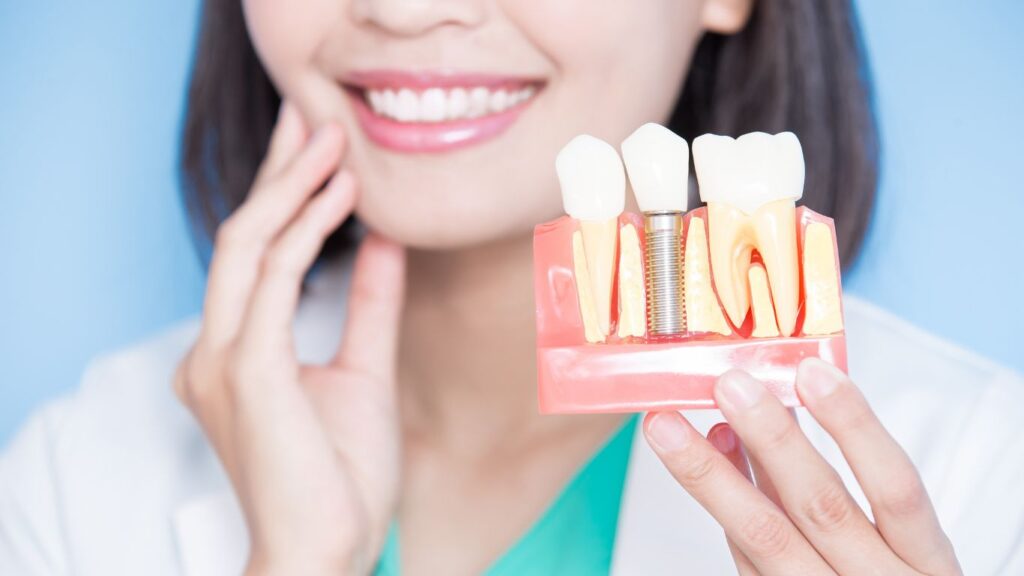 women holistic dentist take implant tooth and touch tooth